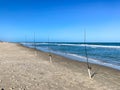 A row of fishing poles with lines cast into the Atlantic Ocean Royalty Free Stock Photo