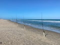 A row of fishing poles with lines cast into the Atlantic Ocean Royalty Free Stock Photo