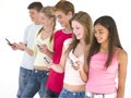 Row of five friends using cellular phones smiling Royalty Free Stock Photo