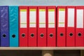 Row of folders for papers and documentation on a shelf in the office Royalty Free Stock Photo