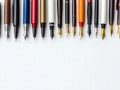 A Row of Fountain Pens Pointing Downwards on a White Background Royalty Free Stock Photo
