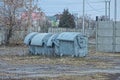 A row of four gray metal trash cans