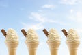 Row of four icecreams against sky