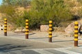 Row of four metal poles to keep cars from driving in a certain area with yellow ribbons to seperate path from parking lot Royalty Free Stock Photo