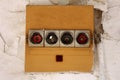 Row of four old vintage disconnected ceramic fuse holders with missing fuses on front side of yellow plastic box on cracked wall