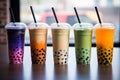 Row of fresh boba bubble tea glasses on a table