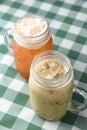 Row of fresh boba bubble tea glasses on wooden table with green plaid tablecloth background. Royalty Free Stock Photo