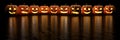 Row of frightening Halloween pumpkins or Jack O'Lanterns with copy space. 3d rendering
