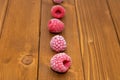 Row of frozen red raspberries on a wooden table Royalty Free Stock Photo