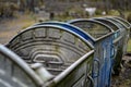 A row of galvanized trash containers. Garbage containers in the park