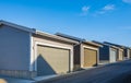 Row of garage doors at parking area for townhouses. New garages in alley. New Alley Construction Royalty Free Stock Photo