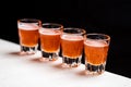 Row of glass of stinger shooters on black background