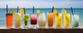 Several cocktails stand on the bar counter with the Ocean beach in the background.