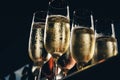 A row of glasses filled with champagne are lined up ready to be served