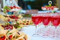 A row of glasses with red drinks, juice, champagne or wine at a party. Catering. Glassware on the table with a white tablecloth. Royalty Free Stock Photo