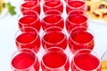 A row of glasses with red drinks, juice, champagne or wine at a party. Catering. Glassware on the table with a white Royalty Free Stock Photo