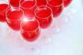A row of glasses with red drinks, juice, champagne or wine at a party. Catering. Glassware on the table with a white Royalty Free Stock Photo