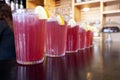 A row of glasses with red, fresh, non-alcoholic cocktail - strawberry lemonade on the bar table. Selective focus. Royalty Free Stock Photo