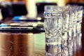 a row of glasses of water in front of a row of pens on a conference table