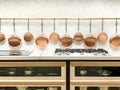 Row of gleaming copper pans hanging on the wall