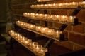 Row of glowing candles in church. Candles with flame on dark background. Faith and religion concept. Candles in catholic church. Royalty Free Stock Photo