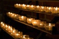 Row of glowing candles in church. Candles with flame on dark background. Faith and religion concept. Candles in catholic church. Royalty Free Stock Photo