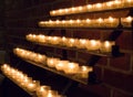 Row of glowing candles in church. Candles with flame on dark background. Faith and religion concept. Candles in catholic church. Royalty Free Stock Photo