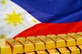 Row of gold bars on the Philippines flag background. Concept of gold reserve and gold fund of Philippines Royalty Free Stock Photo