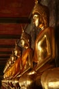 A row of golden Buddha statue inside a temple hall Royalty Free Stock Photo