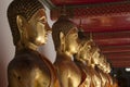 Row of golden buddha statues in temple cloisters Royalty Free Stock Photo