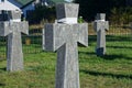 A row of gray stone marble crosses on graves