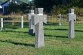 A row of gray stone marble crosses on graves