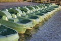 A row of green boats at the wooden pier on the lake in summer Royalty Free Stock Photo