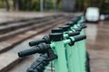 Row of green mint rental motorized kick scooters in the center of rainy city. Electric Urban transportation concept Royalty Free Stock Photo