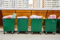 Row of green overfill garbage bins in residential, front view