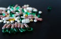 Row of green and pink pills with Lots of different medicine drugs, pills, tablets, capsules on black matte background.  macro Royalty Free Stock Photo