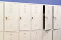 A row of grey metal school lockers with keys in the doors. Storage locker room in corridor of educational institution Royalty Free Stock Photo