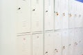 A row of grey metal school lockers with keys in the doors. Storage locker room in corridor of educational institution Royalty Free Stock Photo