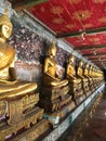 A row of guilded Buddas in one of Bangkok temples