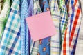 Row of hanging shirts with pink paper note