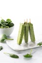 A row of green smoothie popsicles on a marble board against a bright background. Royalty Free Stock Photo