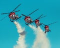 Row of helicopters releasing smoke for an airplane show