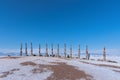 A row of high ritual cult pillars of the Buryats, tied with multi-colored ribbons, on a clear winter day. Sacred Cape Burkhan,