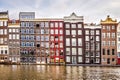 Row of historic Dutch houses along the Damrak canal, dating back to the 18th century, in the historic city center of Amsterdam