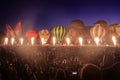 Glowing hot air balloons at night, in front of huge crowd Royalty Free Stock Photo