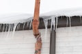 Row of icicles and snow hanging from roof of a house Royalty Free Stock Photo