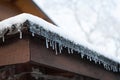 Row of icicles and snow hanging from roof of a house Royalty Free Stock Photo