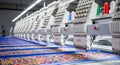 Industrial embroidery machines in a factory producing colorful patterned textiles Royalty Free Stock Photo