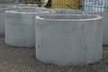 A row of industrial gray concrete rings stand