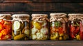 A row of jars filled with a variety of vegetables including pickles, peppers, and carrots